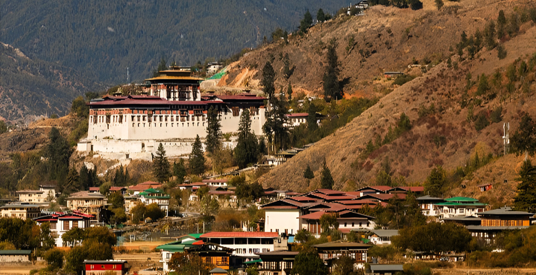 Panoramic view of eastern Bhutan with dzong and snow-capped mountains.